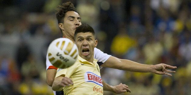 America's Oribe Peralta, front, fights for the ball with Monterrey's Efrain Juarez during a Mexican soccer league match in Mexico City, Sunday, Dec. 7, 2014. (AP Photo/Christian Palma)