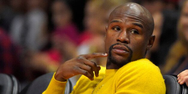 Boxer Floyd Mayweather Jr. watches the Los Angeles Clippers play the Phoenix Suns during the first half of a preseason NBA basketball game, Wednesday, Oct. 22, 2014, in Los Angeles. (AP Photo/Mark J. Terrill)