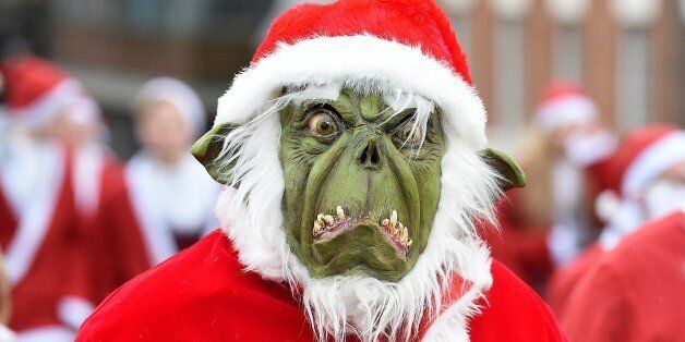 A runner dressed as The Grinch takes part in the annual five kilometer Santa Dash in Liverpool, north-west England, on December 7, 2014. Organisers were hoping to attract more than10,000 runners for the 10th annual race. Many runners wear a blue suit, usually supporters of Everton football club, who refuse to run in red and white, the colours of their city rivals Liverpool FC. AFP PHOTO/PAUL ELLIS (Photo credit should read PAUL ELLIS/AFP/Getty Images)