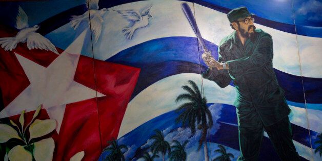 A mural of Fidel Castro playing baseball decorates a wall at the Latin American baseball stadium in Havana, Cuba, late Thursday, Dec. 18, 2014. The announcement on Wednesday that the U.S. plans to restore diplomatic ties with the Caribbean nation could usher in a new era in U.S.-Cuba baseball relations, which were strained after the Castro revolution and the U.S.-led economic embargo. Castro banned professional sports in Cuba in 1962. (AP Photo/Ramon Espinosa)