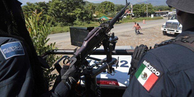 A federal police officer mans a general-purpose machine gun (GPMG) at a checkpoint in Iguala, Guerrero State, Mexico, on October 7, 2014. Mexican federal forces disarmed the southern city's entire police corps and took over security Monday after officers were accused of colluding with a gang in violence that left 43 students missing. AFP PHOTO/Pedro PARDO (Photo credit should read Pedro PARDO/AFP/Getty Images)