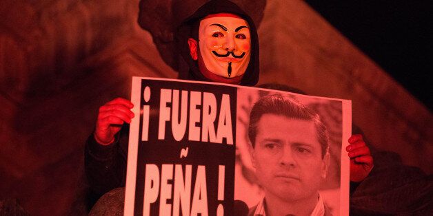 MEXICO CITY, MEXICO - DECEMBER 01: Mexican protestor wearing Guy Fawkes mask attends a rally against President Enrique Pena Nieto's administration on the second anniversary of his term in office in Mexico City, Mexico, on December 01, 2014. PeÃ±a Nieto has been under growing pressure from protesters over government's handling of the case of 43 missing students. (Photo by Daniel Cardenas/Anadolu Agency/Getty Images)