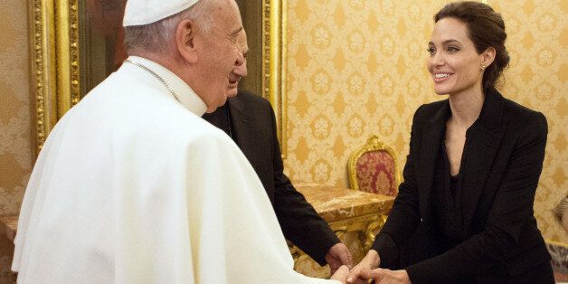 Pope Francis greets Angelina Jolie, at the Vatican, Thursday, Jan. 8, 2015. The actress, director and U.N. special envoy met briefly with Pope Francis Thursday in the Apostolic Palace after screening her film "Unbroken" to some Vatican officials and ambassadors. (AP Photo/L'Osservatore Romano, Pool)