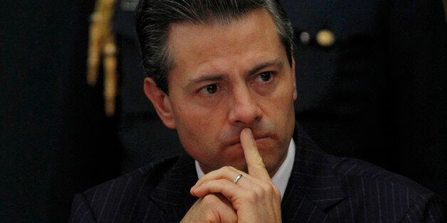 Mexico's President Enrique PeÃ±a Nieto relaxes during the signing of the banking reform bill at the presidential residence, Los Pinos, in Mexico City, Thursday, Jan. 9, 2014. The financial reform encourages banks to improve access to credit and provide customers with better interest rates in an attempt to boost economic growth. (AP Photo/Marco Ugarte)