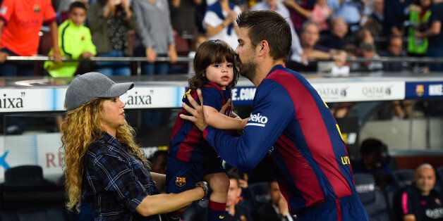 BARCELONA, SPAIN - OCTOBER 18: Gerard Pique of FC Barcelona passes his son Milan to his wife Shakira during the La Liga match between FC Barcelona and SD Eibar at Camp Nou on October 18, 2014 in Barcelona, Spain. (Photo by David Ramos/Getty Images)