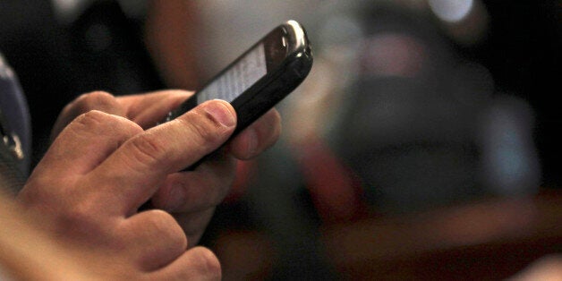 In this photo taken Sept. 14, 2011, a journalist twits in his mobile phone during a news conference in Caracas, Venezuela. Venezuela's political battle is playing out in a new way on Twitter, where the accounts of at least nine critics of President Hugo Chavez have been mysteriously taken over by hackers who post pro-government messages along with insults and threats.(AP Photo/Fernando Llano)