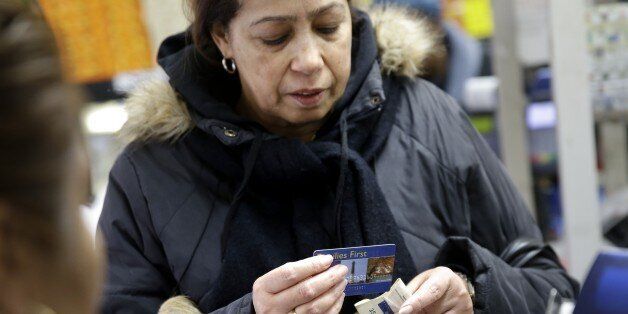 Luisa, who did not want to give her last name, pays for her groceries using a food stamp program at a supermarket in West New York, N.J., Monday, Jan. 12, 2015. New Jersey lawmakers are considering a bill that would require the state to expedite the handling of applications for food stamps. (AP Photo/Seth Wenig)