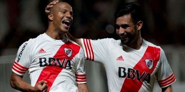 River Plate's Carlos Sanchez, left, celebrates with his teammate Ariel Rojas after scoring a goal against San Lorenzo, during the Recopa Sudamericana final soccer match, in Buenos Aires, Argentina, Wednesday, Feb. 11, 2015. (AP Photo/Rodrigo Abd)