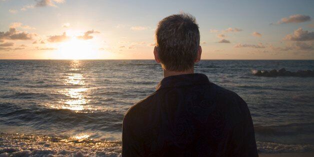 Rear view of man looking out to sea