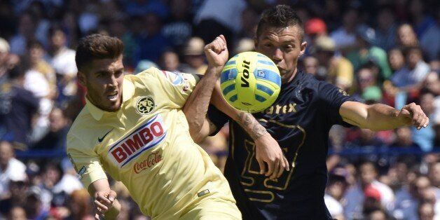 Footballer Dante Lopez (R) of Pumas vies for the ball with Ventura Alvarado of America during their Mexican Clausura tournament match at the Olympic stadium in Mexico City, on February 22, 2015. AFP PHOTO / OMAR TORRES (Photo credit should read OMAR TORRES/AFP/Getty Images)
