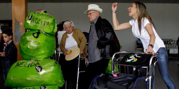 Cubans who live in the U.S. arrive with packages that read "Nelida" to the Jose Marti International Airport as they arrive to Havana, Cuba, Monday, Sept. 3, 2012. A steep hike in customs duties has taken effect Monday in Cuba, catching some air travelers unaware. Nelida Diaz, center left, says she was shocked when officials charged her $588 at customs. The woman at right is speaking to a person who came to get her at the airport. (AP Photo/Franklin Reyes)