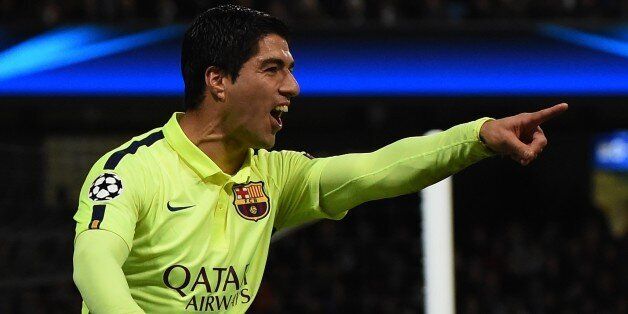 Barcelona's Uruguayan forward Luis Suarez celebrates scoring his and his team's second goal as Manchester City's English goalkeeper Joe Hart (R) dives during the UEFA Champions League round of 16 first leg football match between Manchester City and Barcelona at the Etihad Stadium in Manchester, northwest England, on February 24, 2015. AFP PHOTO / PAUL ELLIS (Photo credit should read PAUL ELLIS/AFP/Getty Images)