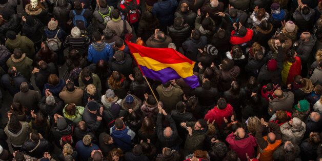 A man waves a Republican flag as people gather in the main square of Madrid during a Podemos (We Can) party march in Madrid, Spain, Saturday, Jan. 31, 2015. Tens of thousands of people possibly more are marching through Madridâs streets in a powerful show of strength by Spainâs fledgling radical leftist party Podemos (We Can) which hopes to emulate the electoral success of Greeceâs Syriza party in elections later this year. (AP Photo/Andres Kudacki)