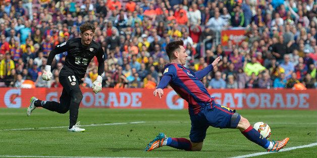 FC Barcelona's Lionel Messi, right, duels for the ball against Rayo Vallecano's goalkeeper Cristian Alvarez during a Spanish La Liga soccer match at the Camp Nou stadium in Barcelona, Spain, Sunday, March 8, 2015. (AP Photo/Manu Fernandez)