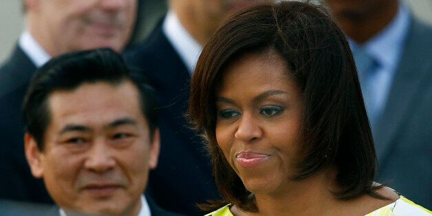 U.S. first lady Michelle Obama smiles upon her arrival at Haneda International Airport in Tokyo Wednesday, March 18, 2015. Obama is visiting Japan and Cambodia, who are among Asia's richest and poorest nations, to highlight cooperation on helping girls finish their educations. (AP Photo/Shizuo Kambayashi)