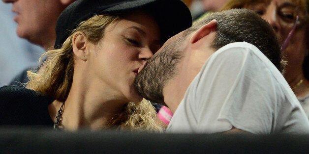 FC Barcelona's player Gerard Pique, right, kisses Colombian singer Shakira as they attend a Basketball World Cup quarterfinal match between Slovenia and United States at the Palau Sant Jordi in Barcelona, Spain, Tuesday, Sept. 9, 2014. The 2014 Basketball World Cup competition will take place in various cities in Spain from Aug. 30 through to Sept. 14. (AP Photo/Manu Fernandez)