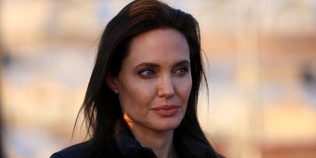 US actress and UNHCR ambassador Angelina Jolie stands during a visit to a camp for displaced Iraqis in Khanke, a few kilometres (miles) from the Turkish border in Iraq's Dohuk province, on January 25, 2015. Run by authorities from the three-province autonomous Kurdish region of north Iraq with the help of the United Nations refugee agency, the UNHCR, Khanke aims to house 18,000 people, said the agency's Liena Veide. AFP PHOTO/SAFIN HAMED (Photo credit should read SAFIN HAMED/AFP/Getty Images)
