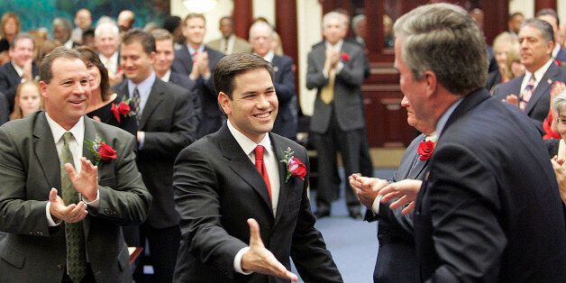 Marco Rubio, R-Coral Gables, center, the new speaker of the Florida House, greets Florida Gov. Jeb Bush, on his way to being sworn in, Tuesday, Nov. 21, 2006, in Tallahassee, Fla. (AP Photo/Steve Cannon)