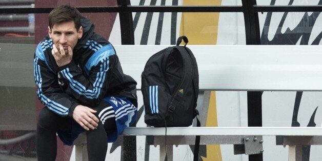 Argentina national football teams Lionel Messi sits on the sidelines at FEDEX Field in Landover, Maryland, March 27, 2015, during a practice session ahead of the Argentina vs. El Salvador friendly match scheduled to play March 28th. AFP PHOTO/JIM WATSON (Photo credit should read JIM WATSON/AFP/Getty Images)