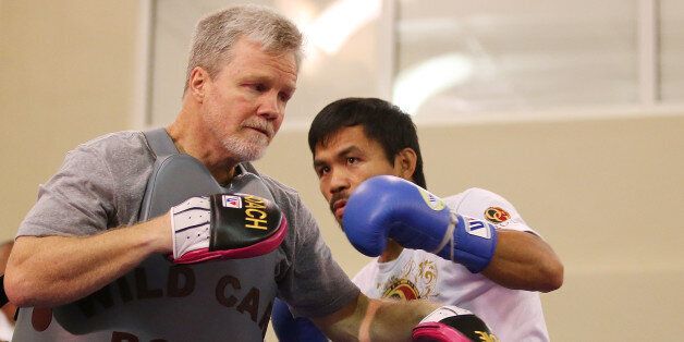 MACAU - NOVEMBER 21: Manny Pacquiao works the mitts with trainer Freddie Roach during a workout session at The Venetianon November 21, 2014 in Macau, Macau. (Photo by Chris Hyde/Getty Images)