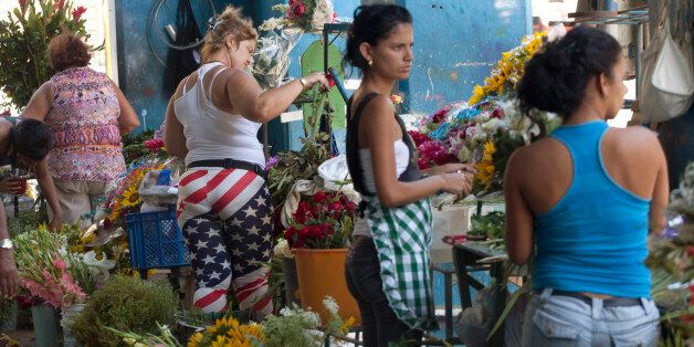 Women, one wearing pants made with the U.S flag colors, work at their stalls selling flowers in Havana, Cuba, Thursday, April 9, 2015. President Barack Obama signaled Thursday he will soon remove Cuba from the U.S. list of state sponsors of terrorism, boosting hopes for improved ties as he prepared for a historic encounter with Cuban President Raul Castro during the Summit of the Americas taking place in Panama. .(AP Photo/Desmond Boylan)