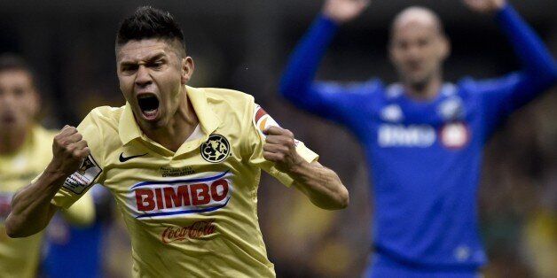 America's forward Oribe Peralta (L) celebrates after scoring against Impact of Montreal during their CONCACAF Champions League first leg final football match at the Azteca stadium in Mexico City on April 22, 2015. AFP PHOTO/ Yuri CORTEZ (Photo credit should read YURI CORTEZ/AFP/Getty Images)