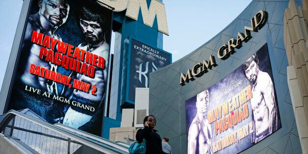 People ride an escalator by signs advertising the Mayweather Pacquiao fight at the MGM Grand Wednesday, April 22, 2015, in Las Vegas. (AP Photo/John Locher)
