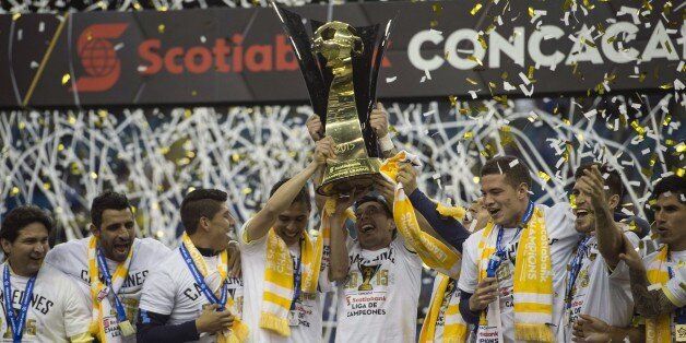 Club America players celebrate with the trophy after defeating the Montreal Impact in the CONCACAF Champions League return leg final 4-2, to win 5-3 on aggregate in Montreal on April 29, 2015. AFP PHOTO/NICHOLAS KAMM (Photo credit should read NICHOLAS KAMM/AFP/Getty Images)