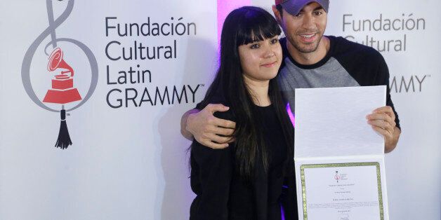Latin Grammy and Grammy winner Enrique Iglesias poses with Latin Grammy Cultural Foundation scholarship recipient Silviana Itzel Salinas-Reyna of Mexico, Wednesday, April 29, 2015, in Miami Beach, Fla. Salinas-Reyna, a 23-year-old tenor saxophone player will receive a scholarship for $200,000 to study at the Berklee College of Music. (AP Photo/Wilfredo Lee)
