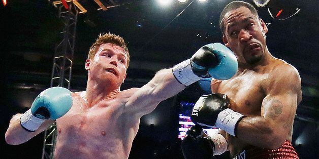 HOUSTON, TX - MAY 09: Canelo Alvarez of Mexico (L) delivers a punch to James Kirkland during their super welterweight bout at Minute Maid Park on May 9, 2015 in Houston, Texas. (Photo by Scott Halleran/Getty Images)