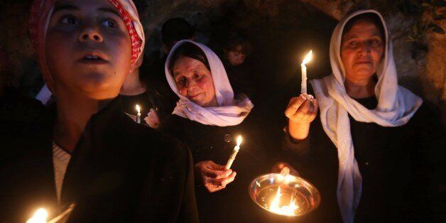 Iraqi Yazidis light candles and paraffin torches outside Lalish temple situated in a valley near Dohuk, 430 km (260 miles) northwest of Baghdad, during a ceremony to celebrate the Yazidi New Year, on April 14, 2015. The Yazidis, who number about 1.6 million, commemorate the arrival of the light into the world during the celebration. AFP PHOTO/SAFIN HAMED (Photo credit should read SAFIN HAMED/AFP/Getty Images)
