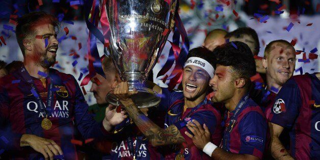 Barcelona's Brazilian forward Neymar da Silva Santos Junior (C) holds the trophy as Barcelona's players celebrate with the trophy after the UEFA Champions League Final football match between Juventus and FC Barcelona at the Olympic Stadium in Berlin on June 6, 2015. FC Barcelona won the match 1-3. AFP PHOTO / OLIVIER MORIN (Photo credit should read OLIVIER MORIN/AFP/Getty Images)