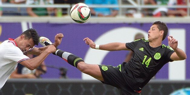 Mexico forward Javier Hernandez (14) kicks Costa Rico defender Giancarlo Gonzalez, left, while going for the ball during the second half of a friendly soccer match in Orlando, Fla., Saturday, June 27, 2015. The teams tied 2-2. (AP Photo/Phelan M. Ebenhack)