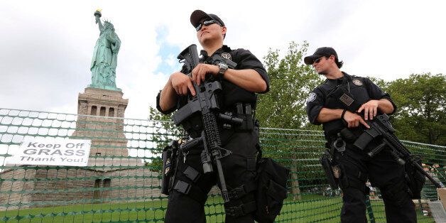 United States Park police swat team members stand guard at the Statue of Liberty, Thursday, July 4, 2013 at in New York. The Statue of Liberty finally reopened on the Fourth of July months after Superstorm Sandy swamped its little island in New York Harbor as Americans across the country marked the holiday with fireworks and barbecues. (AP Photo/Mary Altaffer)