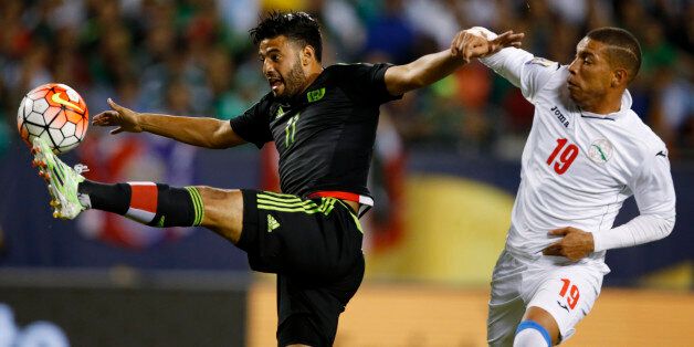 Mexico forward Carlos Vela (11) kicks the ball past Cuba defender Yasmany Lopez (19) during the first half of a CONCACAF Gold Cup soccer match, Thursday, July 9, 2015, in Chicago. (AP Photo/Andrew A. Nelles)