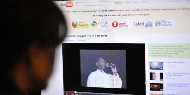 An office worker watches a video made in 1991 and posted on YouTube, featuring the US Republican Party Presidential hopefull Herman Cain performing a version of John Lennon's song 'Imagine' with changed lyrics, on October 18, 2011 in Washington, DC. Cain was CEO of the Omaha-based restaurant chain Godfather's Pizza at the time of his recording release. The latest opinion polls give long-time front-runner Mitt Romney 26 percent for the Republican presidential nomination, with Cain only one point behind at 25 percent, well ahead of the next-placed Texas governor Rick Perry. AFP PHOTO/Mladen ANTONOV (Photo credit should read MLADEN ANTONOV/AFP/Getty Images)