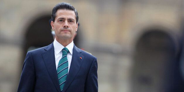 Mexican President Enrique Pena Nieto observes the French flag during a welcoming ceremony, in Paris, Monday, July 13, 2015. Mexican President Enrique Pena Nieto is paying a state visit to France this week amid the shock of drug lord Joaquin "El Chapo" Guzman's dramatic escape from a maximum security prison in Mexico. (AP Photo/Thibault Camus, Pool)
