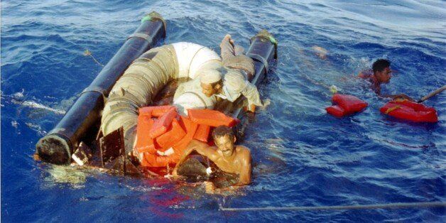 FILE -In this Sept. 11, 1994 file photo, three refugees cling to their overturned raft and life preservers as the U.S. Coast Guard cutter Chandeleur moves in to pick them up approximately 15 miles north of Cuba. In the 20 years since Fidel Castro set off a high-seas humanitarian crisis by encouraging an exodus of 35,000 islanders, more than 26,000 other Cubans have risked their lives crossing the Florida Straits. Already this year, nearly 3,000 have been picked up by U.S. authorities, on a pace to double last years total. Experts say it shows the limits of the wet-foot, dry-foot policy that solved the 1994 crisis. (AP Photo/Alon Reininger, File)