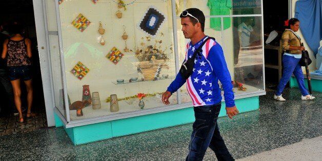 TO GO WITH AFP STORY BY RIGOBERTO DIAZA man wearing a jersey with the US flag colors walks along a street of Havana, on April 13, 2015. AFP PHOTO/YAMIL LAGE (Photo credit should read YAMIL LAGE/AFP/Getty Images)