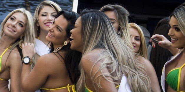 A man takes a selfie with candidates to the Miss Bumbum Brazil 2015 pageant at Paulista Avenue in Sao Paulo, Brazil on August 3, 2015, during an event to promote the contest. All eyes are on Brazil's annual Miss Bumbum pageant in Sao Paulo on November, 9 to select the nation's sexiest female derriere. AFP PHOTO / Nelson ALMEIDA (Photo credit should read NELSON ALMEIDA/AFP/Getty Images)