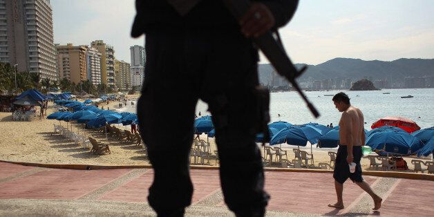 ACAPULCO, MEXICO - MARCH 04: A Mexican federal policeman stands guard near the beach on March 4, 2012 in Acapulco, Mexico. Drug violence has surged in the coastal resort in the last year, making Acapulco the second most deadly city in Mexico after Juarez. One of Mexico's top tourist destinations, Acapulco has suffered a drop in business, especially from foreign tourists, due to the violence. Toursim accounts for about 70 percent of the economy of Acapulco's state of Guerrero and 9 percent of Mexico's economy. (Photo by John Moore/Getty Images)