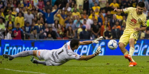 MEXICO CITY, MEXICO - AUGUST 11: Oribe Peralta of America scores against Luis Michel of Dorados during a 4th round match between America and Dorados as part of the Apertura 2015 Liga MX at Azteca Stadium on August 11, 2015 in Mexico City, Mexico. (Photo by Miguel Tovar/LatinContent/Getty Images)
