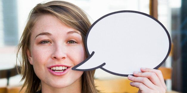Young woman holding empty speech bubble