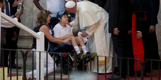 Pope Francis greets a child on a wheelchair during a meeting with a group of Cuban youth in Havana, Cuba, Sunday Sept. 20, 2015. Pope Francis met with Fidel Castro on Sunday before finishing the day with a vespers service in Havana's cathedral, and then meeting with the youths. (AP Photo/Ramon Espinosa)