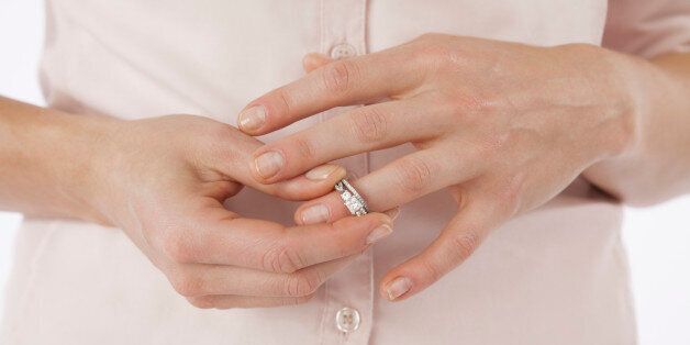 Close-up of woman removing wedding ring from finger