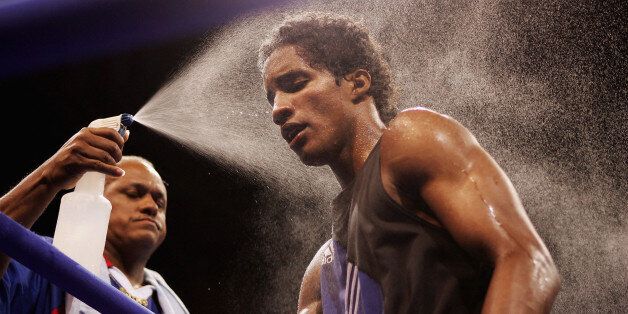 ATHENS - AUGUST 16: Carlos Velazquez of Puerta Rica is spray blasted in between rounds of his fight against Edvaldo Oliveira of Brazil during the men's boxing 57 kg preliminary bout on August 16, 2004 during the Athens 2004 Summer Olympic Games at Peristeri Olympic Boxing Hall in Athens, Greece. (Photo by Michael Steele/Getty Images)