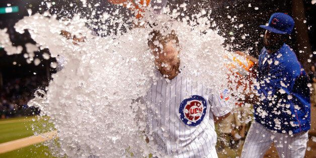 CHICAGO, IL - SEPTEMBER 28: Chris Denorfia #15 of the Chicago Cubs is doused by Anthony Rizzo (not pictured) and Dexter Fowler #24 (R) after hitting a walk-off home run against the Kansas City Royals at Wrigley Field on September 28, 2015 in Chicago, Illinois. The Chicago Cubs won 1-0 in eleven innings. (Photo by Jon Durr/Getty Images)