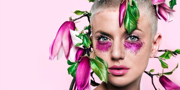 portrait of beautiful woman with pink glitter make-up and magnolia