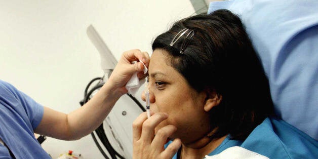 Singapore, SINGAPORE: Singapore's most renowned plastic surgeon, Woffles Wu injects Botox treatment to a customer forehead at his clinic in Singapore, 06 April 2006. Plastic surgeons say they have noted a sharp increase in operations for young Singaporeans -- including some boys. The most popular operations for women are creating double eyelids along with nose jobs and breast implants, while some men go for chin improvement. AFP PHOTO/ROSLAN RAHMAN (Photo credit should read ROSLAN RAHMAN/AFP/Getty Images)