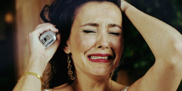 Woman crying and holding telephone